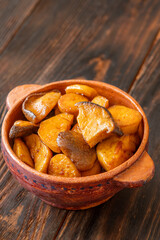 Fototapeta premium Sautéed baby Eryngii mushrooms caramelized to golden perfection served in rustic clay pot elegantly