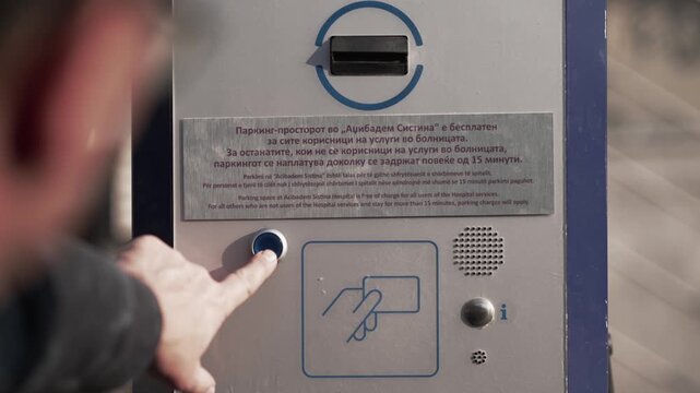 Driver taking a ticket to pass parking barrier in parking lot area