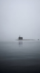 Fototapeta premium Misty morning naval submarine emerges from fog on calm water a silent sentinel of the deep sea mystery and power