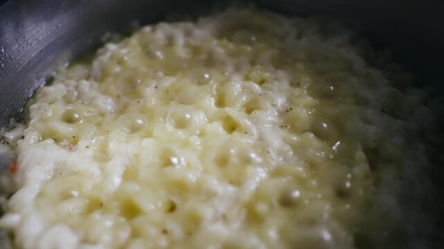 Cooking rice in metal pan on hotplate in kitchen