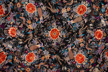 Obraz premium Sevilla, Spain - 23 Dec 23: Colorful floral embroidery pattern on black textile, Seville museum
