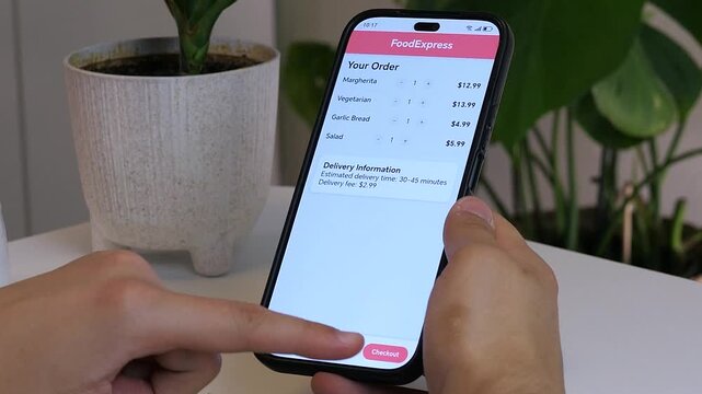 Close-up of hands ordering pizza in a modern food delivery app on smartphone. User adds items and proceeds to checkout at home. Concept of online shopping, mobile payment, fast delivery and digital