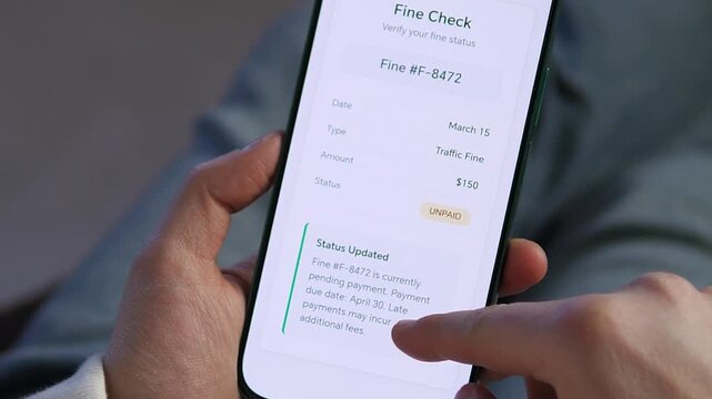 Close-up of a person checking a traffic fine status via a modern mobile app. Sleek UI displays violation details and unpaid status. Perfect for videos about digital government services, smart city