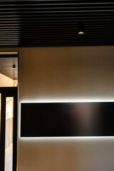 Obraz premium Modern interior wall with illuminated panel and sleek ceiling design