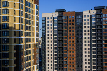 Naklejka premium Modern residential buildings with varied facades against clear blue sky