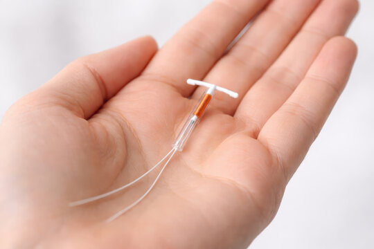 Copper IUD Birth Control Device on Woman Palm