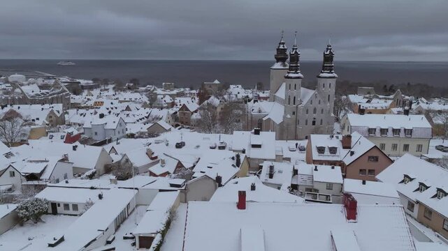 Winter Drone Pullback From Visby Cathedral and Old Town Revealing City Wall, Gotland Sweden