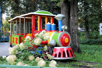 There is a steam locomotive in the park for small children to take for rides.