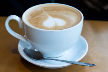 Fototapeta premium Hot latte with heart shaped foam art in cafe in Da Lat, Vietnam