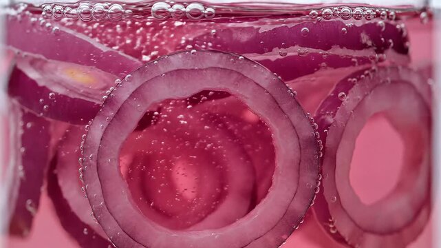 Close up of sparkling beverage with red onion slices and bubbles