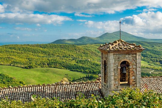 2019-11-01 VIEW OF A TUSCAN VALLEY WITH LUSH FOLIAGE AND ANICE SKY WITH A BELL TOWER AND ROOF TOP NEAR MONTIVERDI ITALY