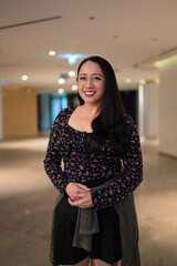 Obraz premium Portrait of smiling Asian woman wearing glasses in contemporary indoor lobby space