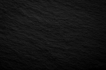 Black textured surface shows smooth and rough patterns with natural variation in light at different...