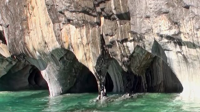 Witness magnificent General Carrera Lake Marble Caves in Patagonia. Azure waters gently lap against intricately sculpted rock formations, revealing nature stunning artistry. Serene daytime exploration