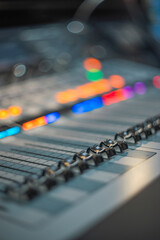 Obraz premium Professional Mixing Console Faders Close-up with Colorful Bokeh and Copy Space