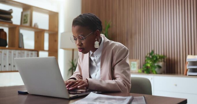 Black woman, laptop and typing in office for legal research, case preparation and drafting lawsuit report. Business attorney, employee and technology for online court review, planning and email