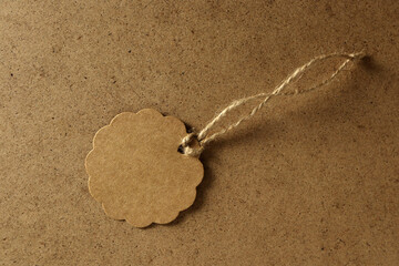 Brown tag on a plain surface with string for gift labeling or decoration purposes