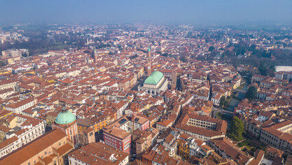 Obraz premium Aerial view of Vicenza, Italy, showcasing the iconic Basilica Palladiana, Torre Bissara, and charming terracotta rooftops under a hazy winter sky. UNESCO World Heritage site.