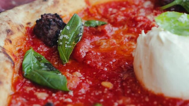 Delicious pizza with meatballs, stracciatella, and burrata, topped with basil and tomato sauce. Italian cuisine concept.