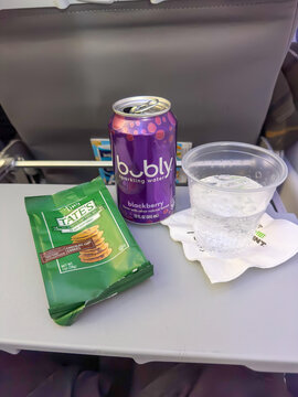 An Open Can of bubly Blackberry Sparkling Water, a Bag of Tate's Tiny Chocolate Chip Cookies