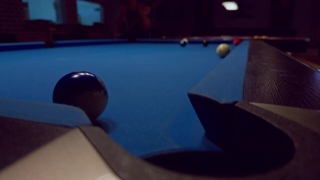 Low Angle View Of Blue Pool Table Corner With Soft Focus Lights Creating Dramatic Night Atmosphere Inside Billiard Club