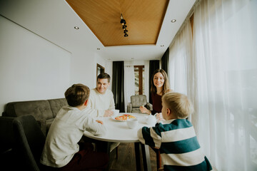Family enjoys breakfast together in modern apartment during morning hours