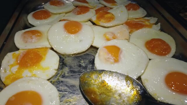 Tourist pov taking an egg from container with fryed eggs from metal tray in restaurant self service buffet. Self service all inclusive hotel vacation