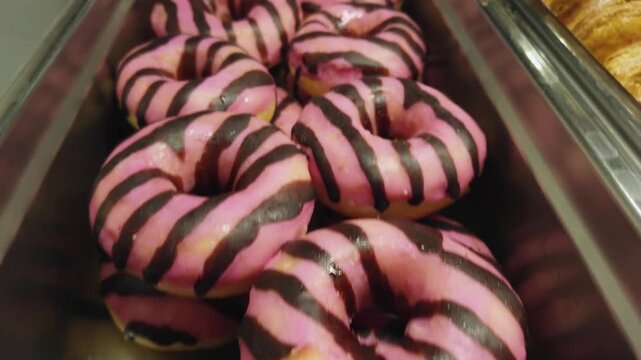 Bakery donuts with colorful decoration glazure on shelf display in candy shop