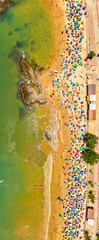 Obraz premium Aerial view of crowded Praia do Morro beach during summer tourism season in Guarapari Brazil