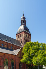The Dom tower of a Catholic church in Riga, Latvia. Photo taken from the bottom up against a blue sky.