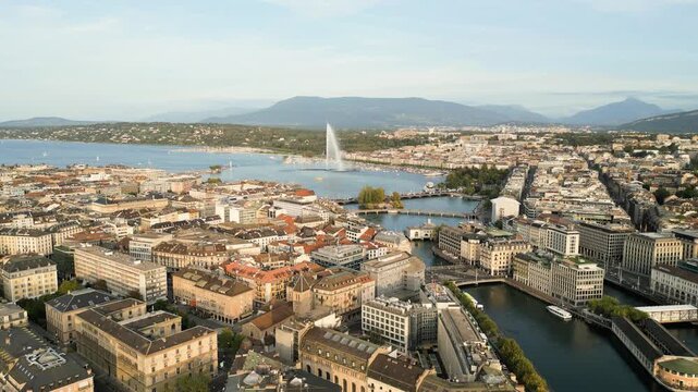 Geneva, Switzerland skyline view towards the Jet d'Eau fountain in Lake Geneva at dusk.