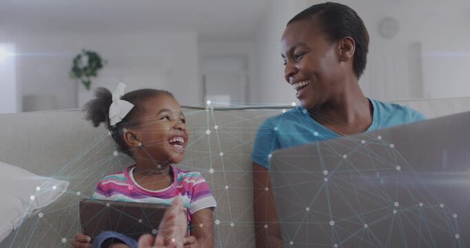 Child tapping tablet and laughing mom on laptop turning to kid bonding tech overlay linking screens