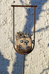 Nails in the head, wooden figure in the garden