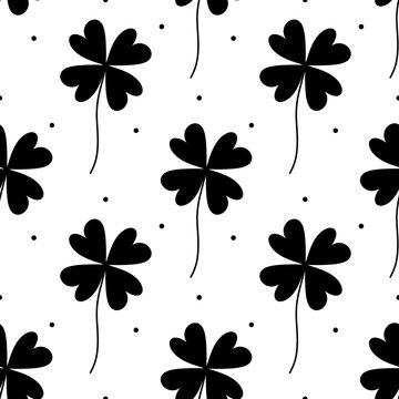 Seamless raster pattern with black four-leaf clovers and polka dots on a white background