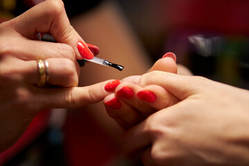 Women's manicure. Female hand undergoing a manicure procedure. The master does a women's manicure. A manicurist files a women's nails in a salon. Hygiene and hand care for woman. manicure design.