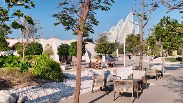  Zayed National Museum is viewed from public Al Masar Garden on Saadiyat Island in Abu Dhabi, highlighting modern architecture and landscaped public space.