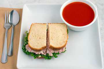 spam salad sandwich  with  a bowl of  tomato soup
