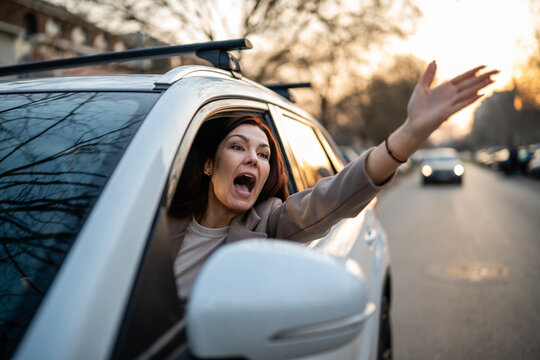 Furious woman yelling driving car showing road rage