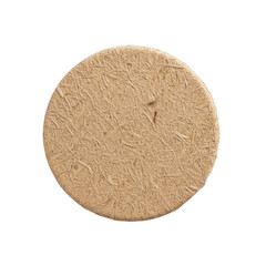 Fototapeta premium A round cork coaster with a textured surface on a white background