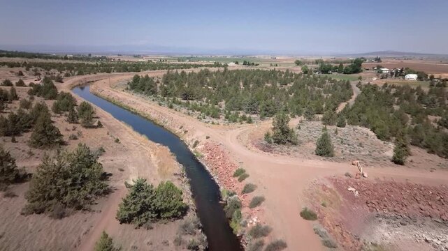 Aerial drone footage of an irrigation canal with water in the arid western U.S.