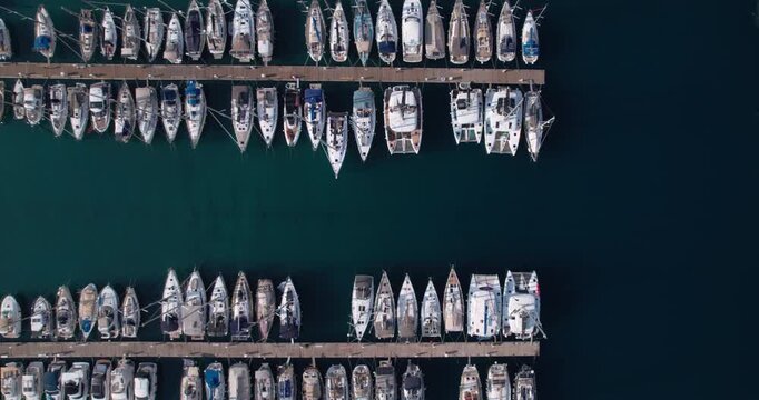 Aerial Marina Lone Tender Crossing Between Docks In Deep Turquoise Water, Slow Maneuver Creates Wake And Dark Channel Line, Moody Quiet Transit Perfect For Travel