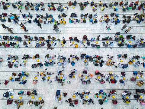 Dhaka, Bangladesh - 03 March 2026: Aerial view of worshippers gathered at the National Mosque, their colorful clothing creating a vibrant mosaic against the geometric patterns of the courtyard.