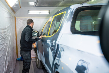 Naklejka premium Mechanic preparing car for painting in auto repair shop