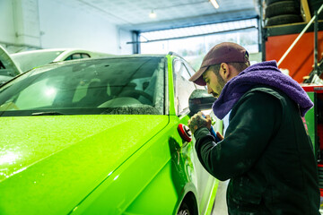 Mechanic buffing car paint for repair and detailing