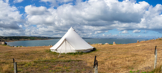Vista panorámica de un precioso paisaje de cielo azul con nubes blancas , una tienda de tela grande sobre el césped amarillo y al fondo el mar en Normandia  zona de Cap-Lévi, viajando en verarno 2022 © acaballero67