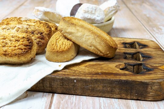 Polvorones and mantecados, traditional Christmas cakes from Andalusia, Spain, on wooden background, view from above. Copy space