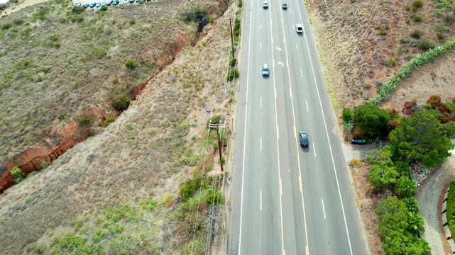 Aerial view of cars driving on coastal highway near the ocean cliffs