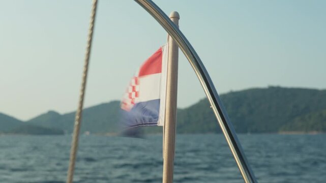 Flag Flutters Brightly. Coastal Breeze Causes Croatian Flag To Wave Lively. Croatian Tricolor Flutters Vigorously On Stern Mast As Gentle Coastal Wind Blows