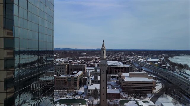 Drone view of snowy Springfield Massachusetts with glass office tower and clock tower