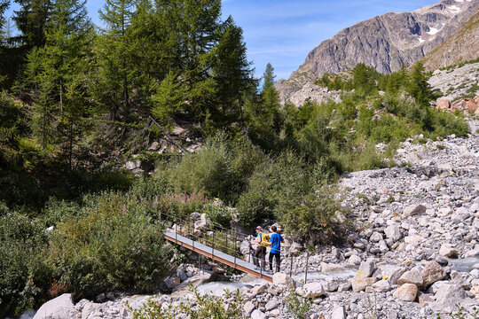 Hikers crossing a metal bridge during a hike